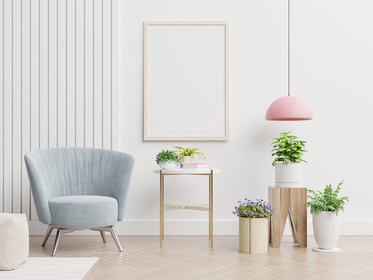 Poster Mockup with Two Vertical Frames on Empty White Wall in Living Room Interior with Blue Velvet Armchair.